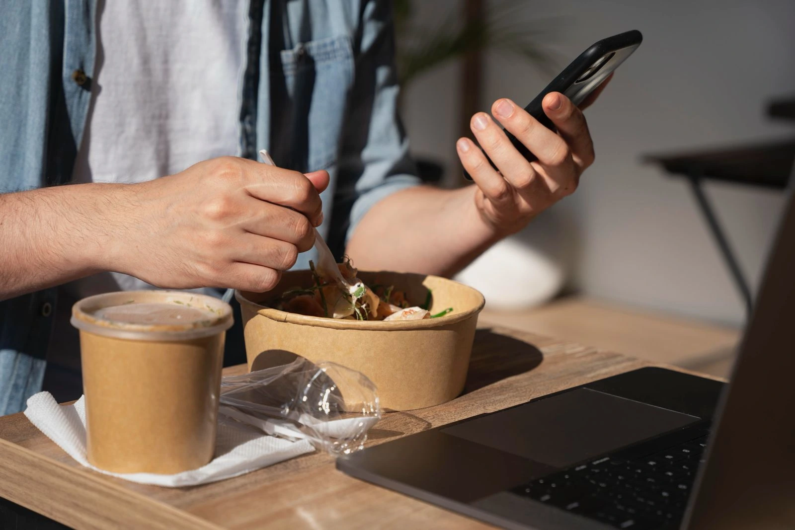 Pelanggan menikmati layanan pesan-antar kuliner ramah lingkungan sambil menggunakan smartphone